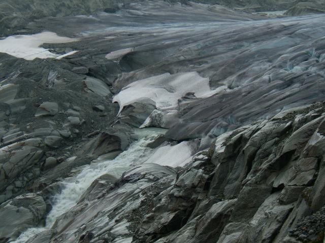 Close view of the water of the Rhone river runing out of the ice of the Rhone Glacier